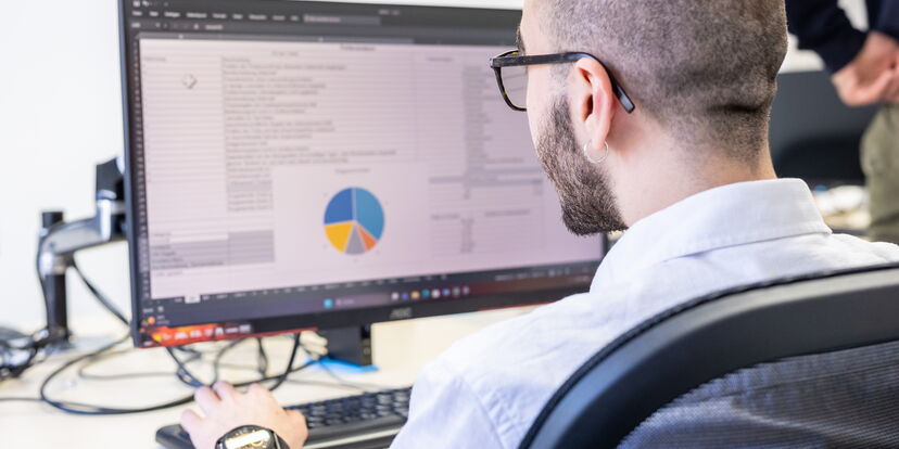 Blick über dir Schulter eines Schülers auf einen Bildschirm mit einem Tortendiagramm.