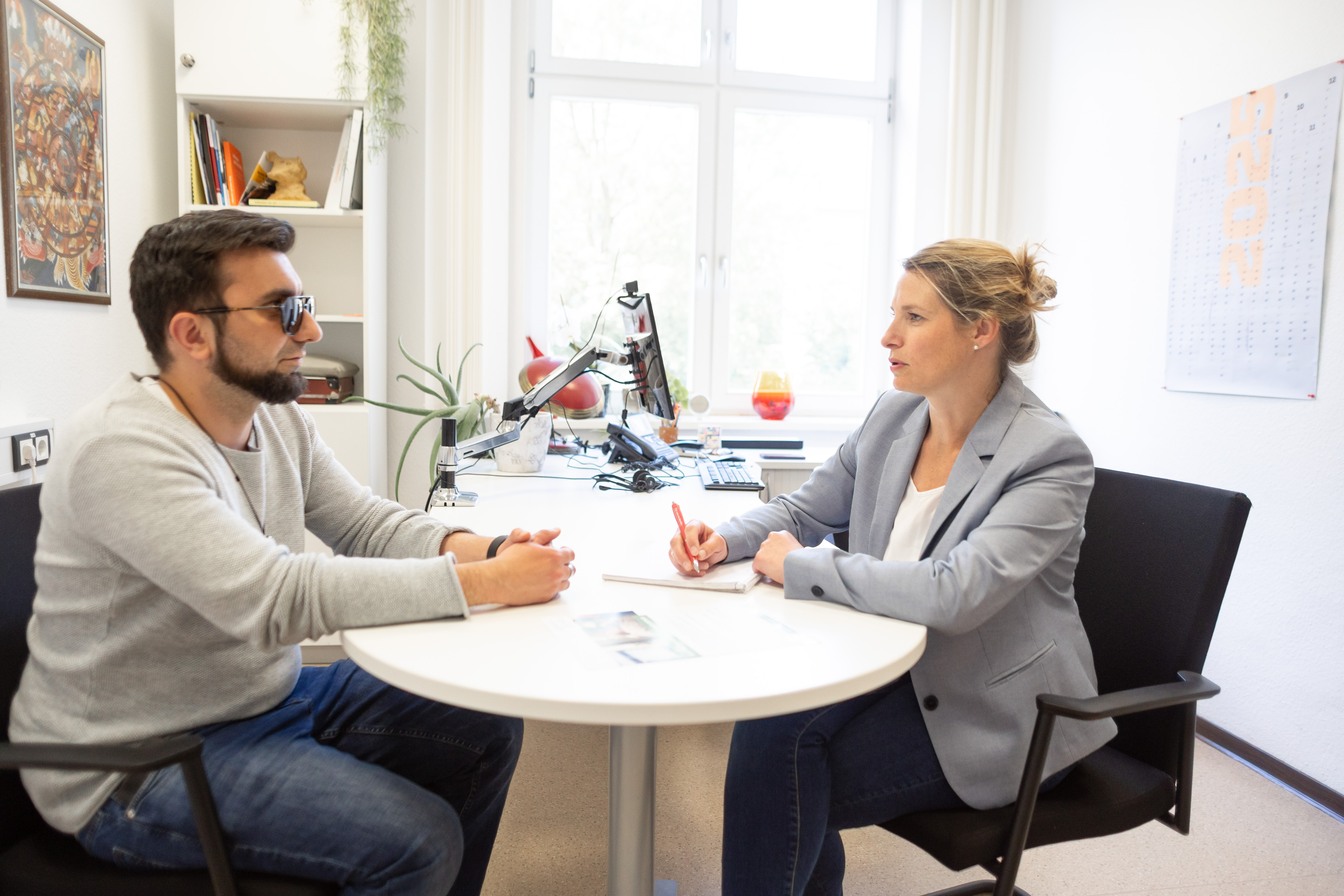 In einem Büro sitzen ein Mann und eine Frau im Gespräch.