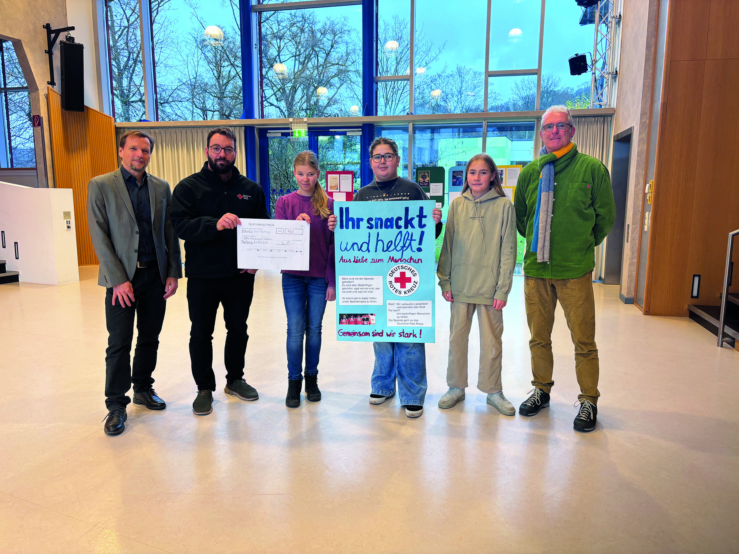 Die Ethikgruppe, ihr Lehrer Gerrit Arnold und Schulleiter Peter Audretsch bei der Übergabe des Schecks an Johannes Klotz vom DRK